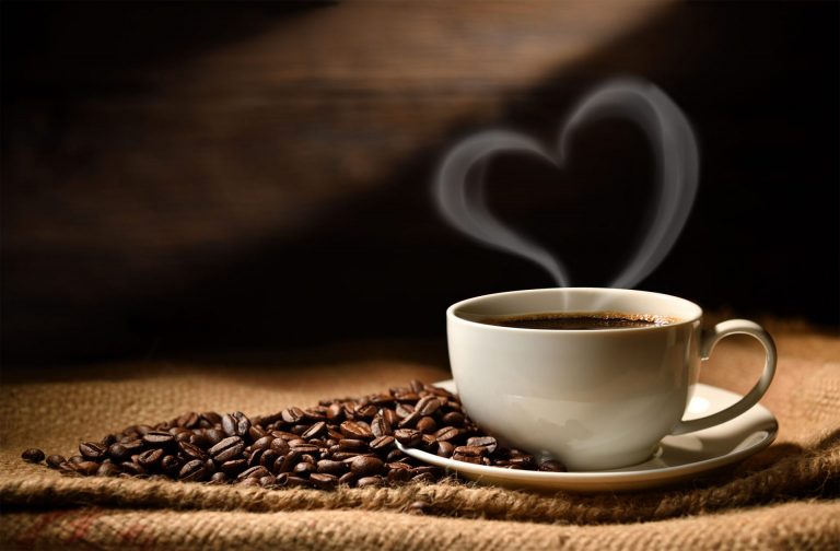 coffee cup surrounded by coffee beans and a heart made out of steam coming out of the top